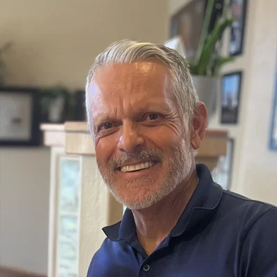 Oscar Castro smiling in a blue collared shirt.